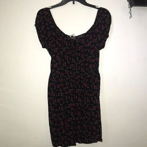 Black over the shoulder dress with red flowers.